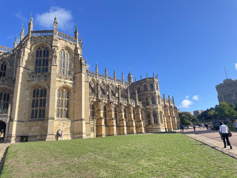Une bibliothèque ancienne remplie de livres classiques anglais reliés en cuir, avec des détails architecturaux victoriens